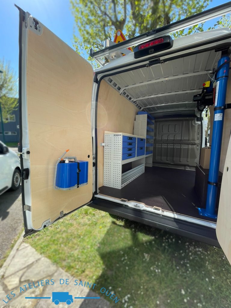 Véhicule aménagé d'un habillage bois avec plancher antidérapant mobilier métallique et potence de chargement