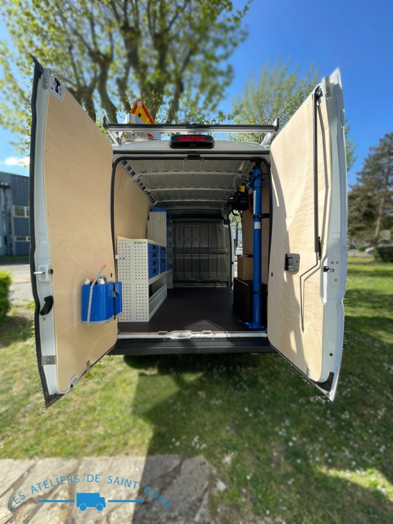 Véhicule aménagé d'un habillage bois avec plancher antidérapant mobilier métallique et potence de chargement