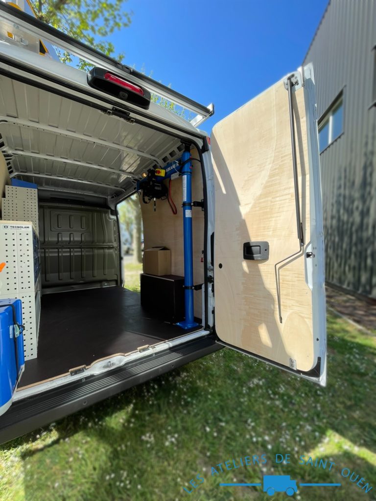 Véhicule aménagé d'un habillage bois avec plancher antidérapant mobilier métallique Mul T Lock et potence de chargement