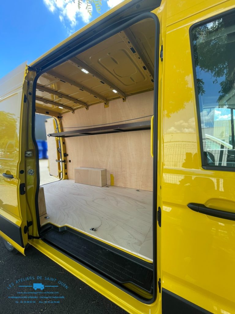 Véhicule aménagé d'un habillage bois avec étagère relevable gauche en cp filmé brun clair