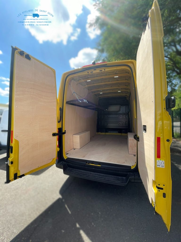 Véhicule aménagé d'un habillage bois avec étagère relevable gauche en cp filmé brun clair