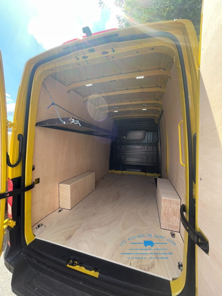 Véhicule aménagé d'un habillage bois avec étagère relevable gauche en cp filmé brun clair